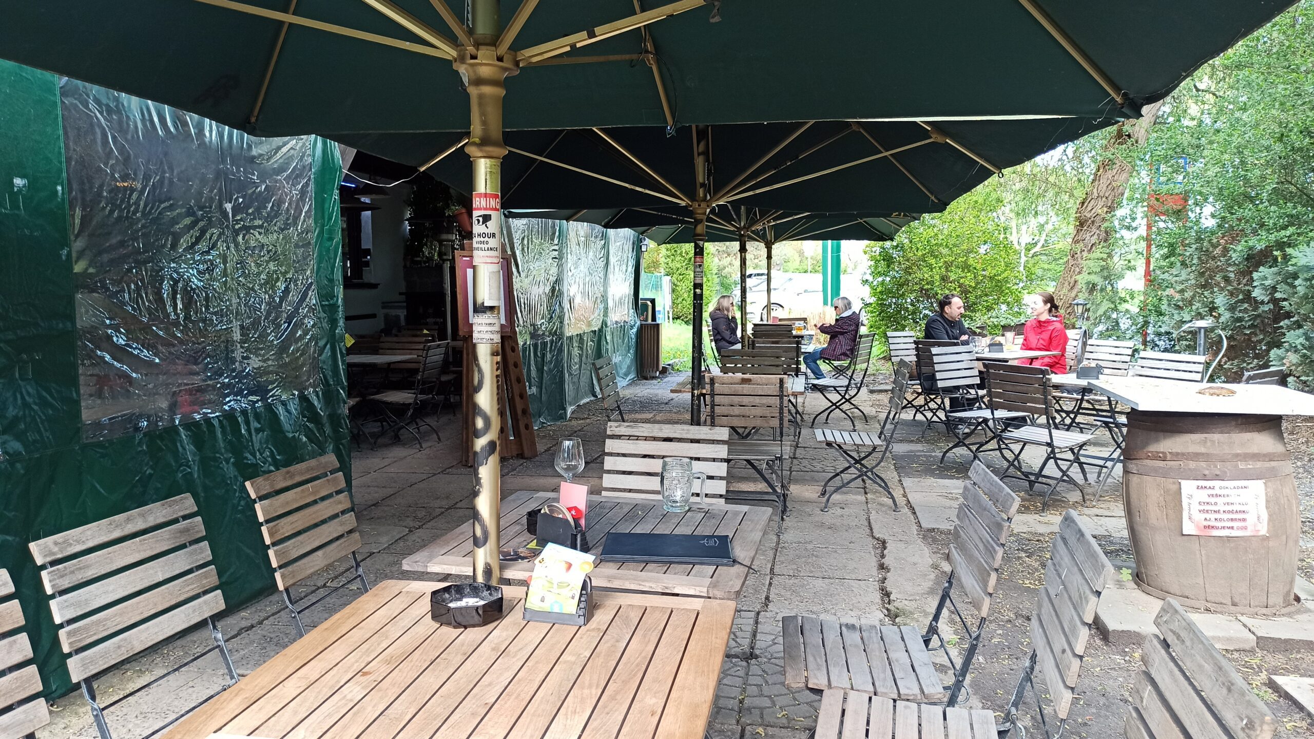 Venkovní zahrádka restaurace U rybníka se zelenými slunečníky